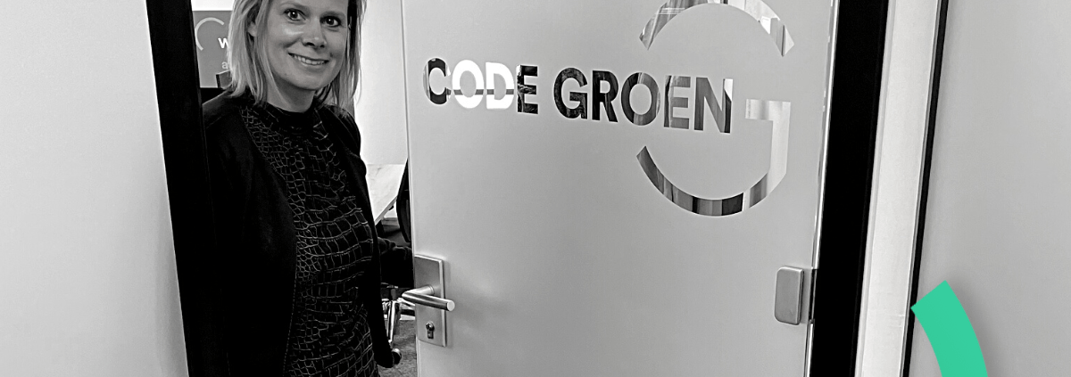 Claire bij de kantoordeur met het Code Groen logo.