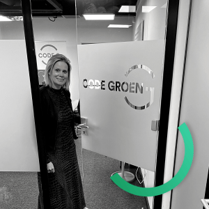 Claire bij de kantoordeur met het Code Groen logo.